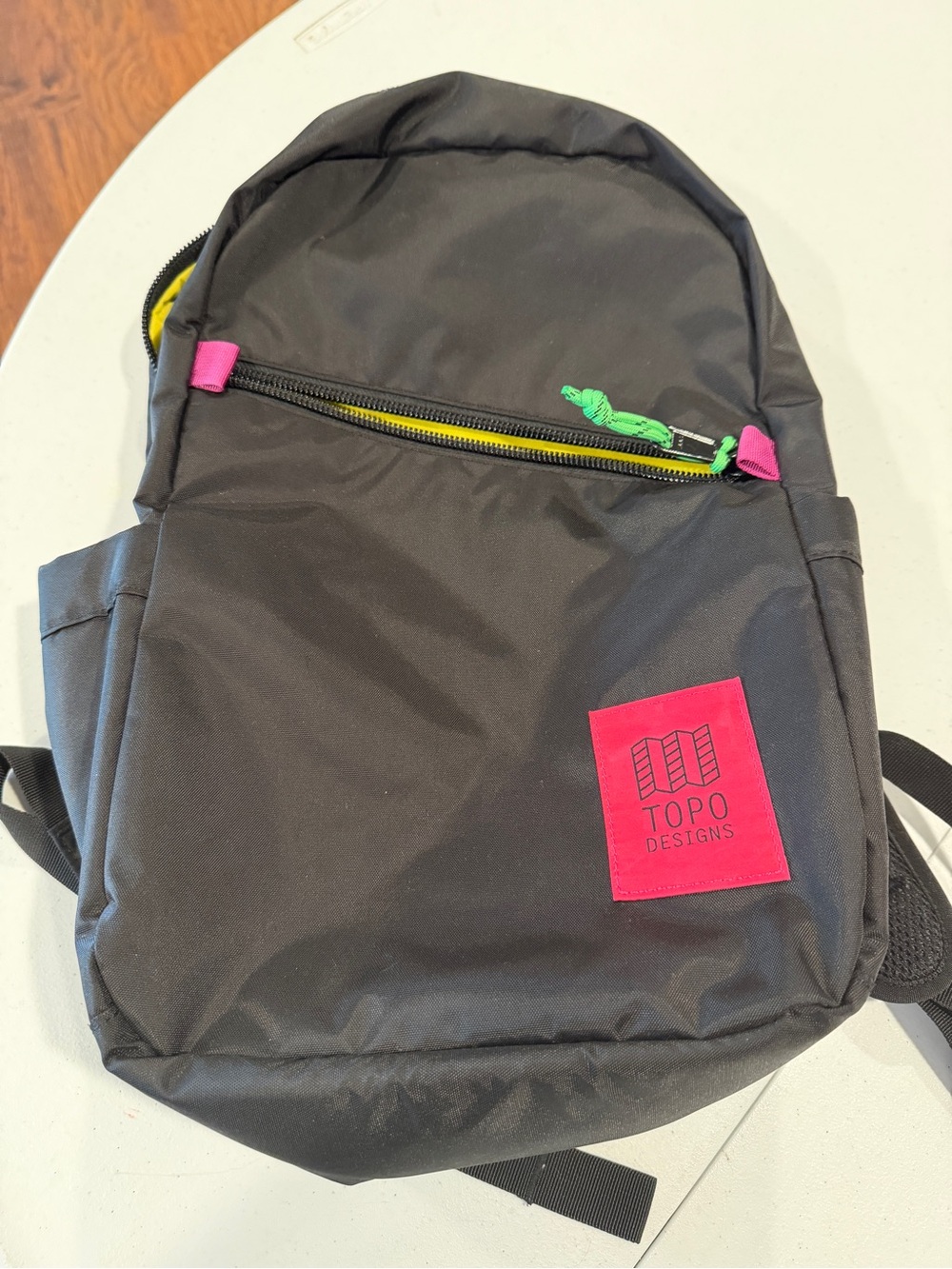 Topo Designs Black Backpack with Pink Logo Patch and Green Zipper Pull
